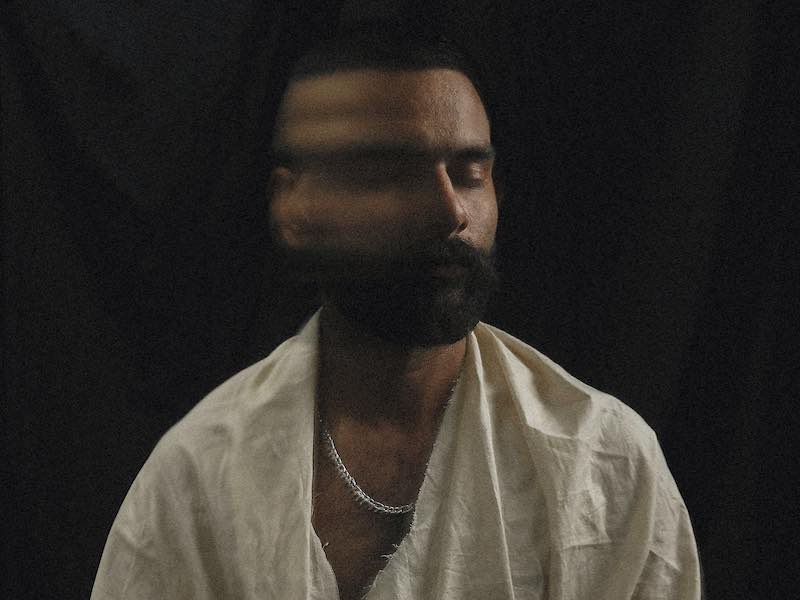 A man in calm reflection as a blurred motion effect represents the conscious shift away from emotional doomscrolling and negative repetitive thoughts.